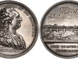 an old silver coin with a woman ' s profile and a bridge in the background