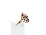 a close up of a gold ring with pink and white stones