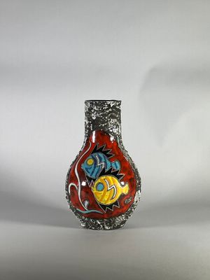 un vase rouge orné d'un motif de poisson