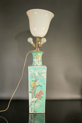 une lampe posée sur une table à côté d'un mur