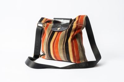 un sac à main rayé orange, noir et blanc, muni d'une bandoulière noire