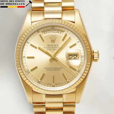 an image of a gold rolex watch sitting on a white surface