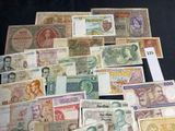 many different types of foreign currency laid out on a black surface