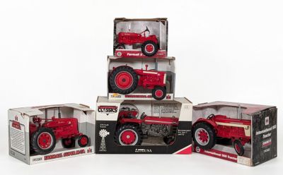 three red toy tractors are stacked on top of each other