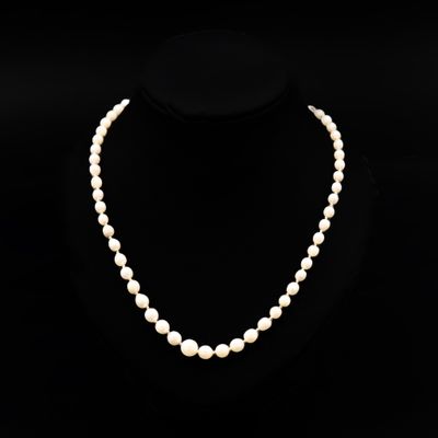 un collier de perles blanches sur un mannequin noir