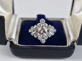 une photo d'une bague en diamant dans un écrin posé sur une surface blanche