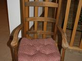 a wooden rocking chair with a red and white checkered seat pad