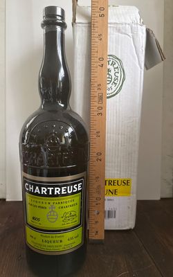 une bouteille de vin posée sur une table à côté d'une règle