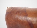 a close up of a brown leather bag on a white surface