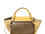 a brown and yellow handbag sitting on top of a white surface