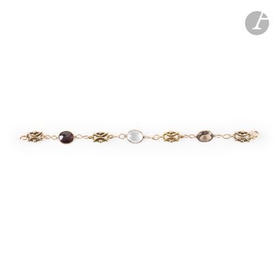 a gold chain bracelet with three different colored stones