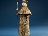 an old statue of a man with a cane and a hat