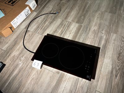 a black stove top sitting on the floor next to a box