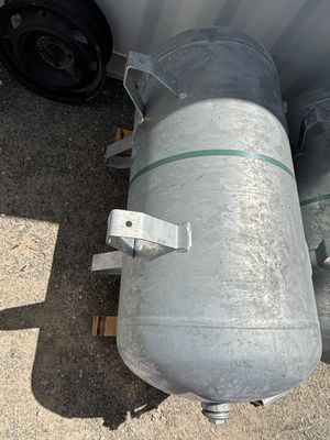 un réservoir métallique posé sur une palette à côté d'un camion