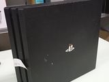 une console de jeux Sony PlayStation noire posée sur une table