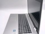 a silver laptop computer sitting on a white surface