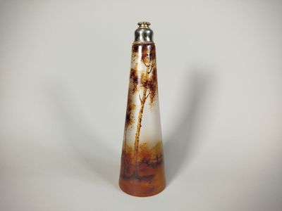 a brown and white vase that is on a white table