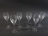 several empty wine glasses are lined up on a black surface