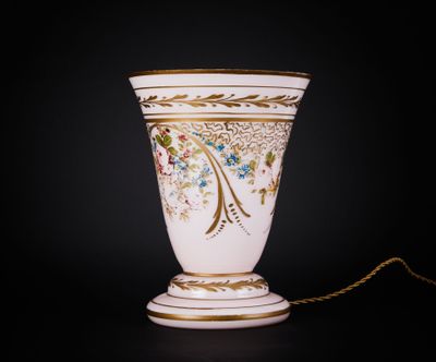 un vase blanc orné d'une bordure dorée et d'une chaîne, sur fond noir