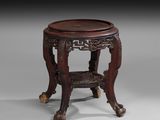 une table orientale avec un plateau en bois et des pieds sculptés