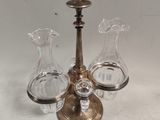 trois vases en verre et un bougeoir en laiton posés sur une table