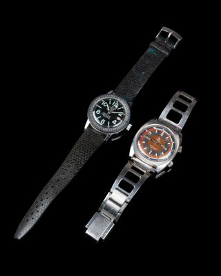 deux montres assises l'une à côté de l'autre sur une surface noire