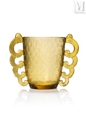 un vase en verre jaune avec une anse dorée sur fond blanc
