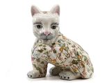 une figurine de chat posée sur une surface blanche