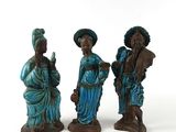 trois figurines représentant des personnes debout les unes à côté des autres sur une surface blanche