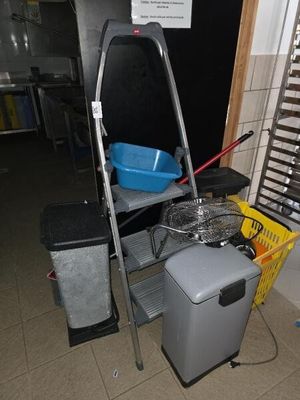 une photo d'une pièce avec une machine à laver et une poubelle