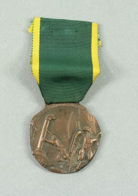 a bronze medal with a green ribbon around it