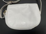 a white purse sitting on top of a black table