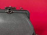 the black purse is sitting on a red surface