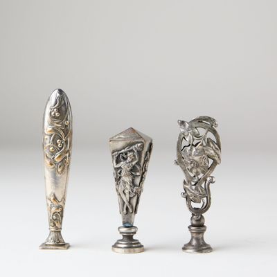 two silver spoons and a silver spoon with a lion head on them