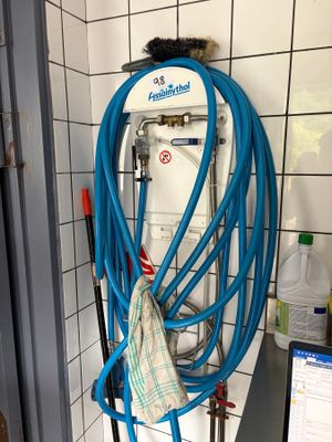 un tuyau bleu fixé au mur d'une salle de bains