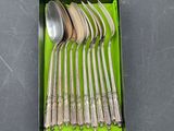 six spoons in a green box on a table