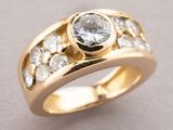 a close up of a gold ring with a white diamond