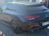 the rear end of a black mercedes cla parked in front of a building