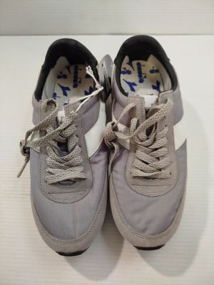 pair of gray sneakers with white laces on them on a white surface