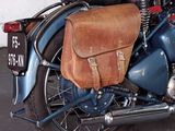 a blue motorcycle with a brown bag on the back