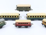 five toy trains sitting next to each other on a white surface
