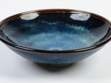 blue and black bowl on a white surface with a white background