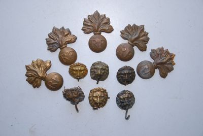 several antique brass leaf and acorns on a white surface