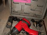 a red cordless drill in a case with a pink sticker on it