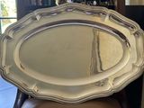 a silver tray sitting on top of a chair in front of a window
