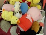de nombreuses peluches entassées dans une boîte posée sur la table