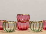 six verres roses et verts posés sur une table en bois