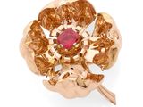 une image montrant un gros plan d'une bague en or sertie d'une pierre rouge