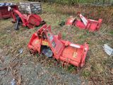un tracteur rouge assis dans l'herbe