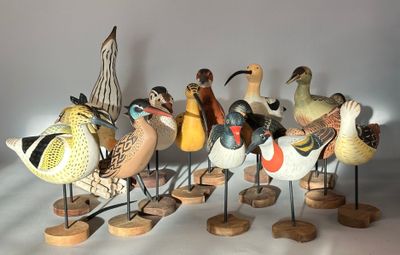 a lot of birds that are standing on wooden stands